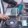 DJ sorting through songs to play at a gig. DJ Service Packs make it easier for DJs to play your music.